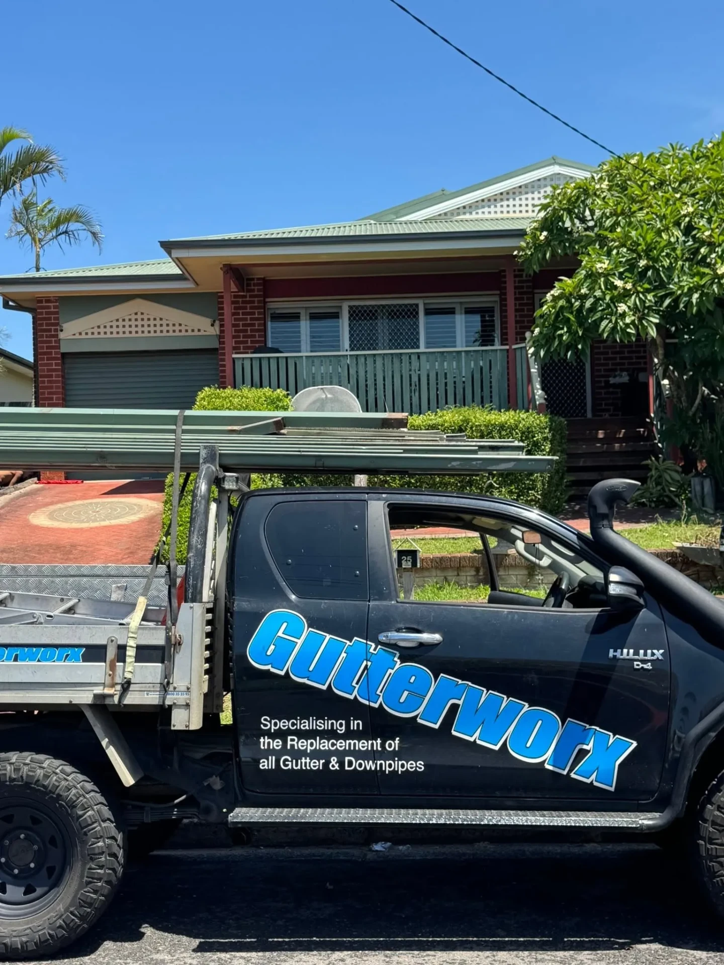 The signwritten Gutterworx ute loaded with new gutter lengths outside a Central Coast home
